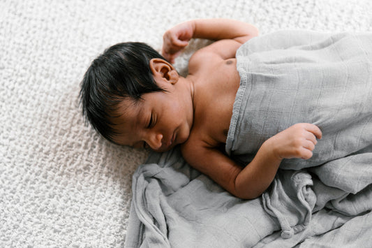 Image of newborn wrapped in gray blanket